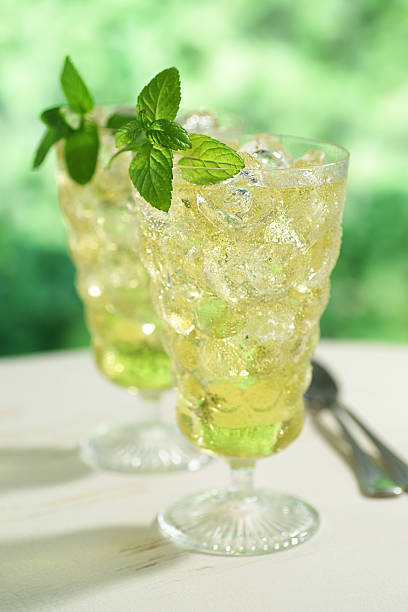 Two glasses of iced green tea garnished with mint.